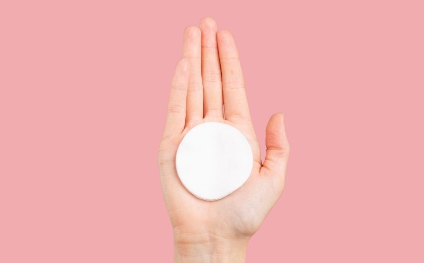 A hand with a cotton pad