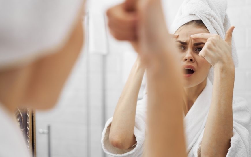 Face steaming prevents acne Woman looking at the mirror terrified