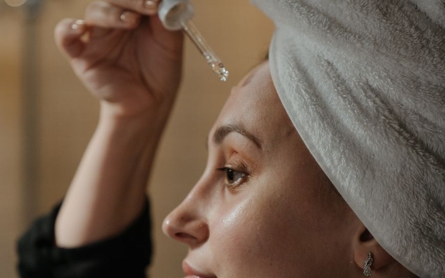 Woman applying a serum on her face