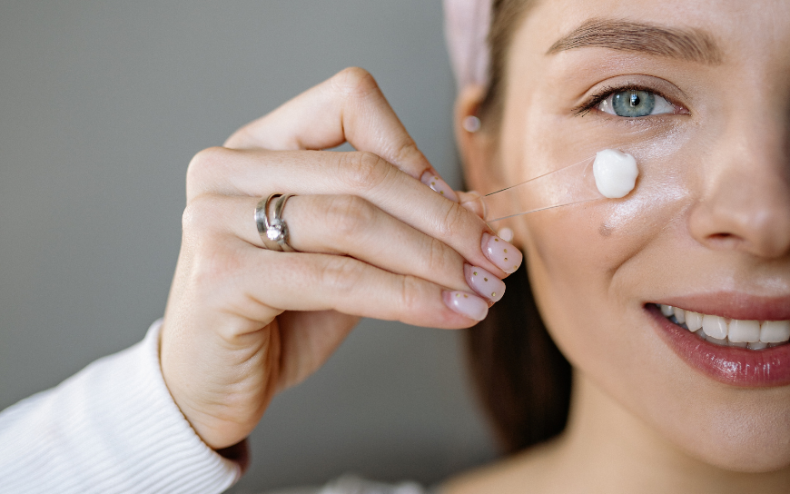 Use an eye cream Woman applying an eye cream
