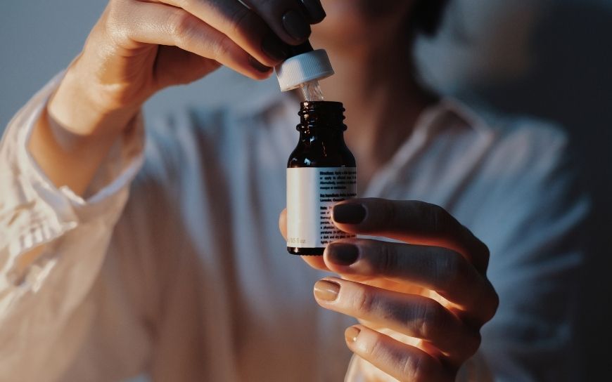 Woman opening a serum bottle