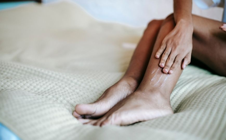 Woman applying a body moisturizer