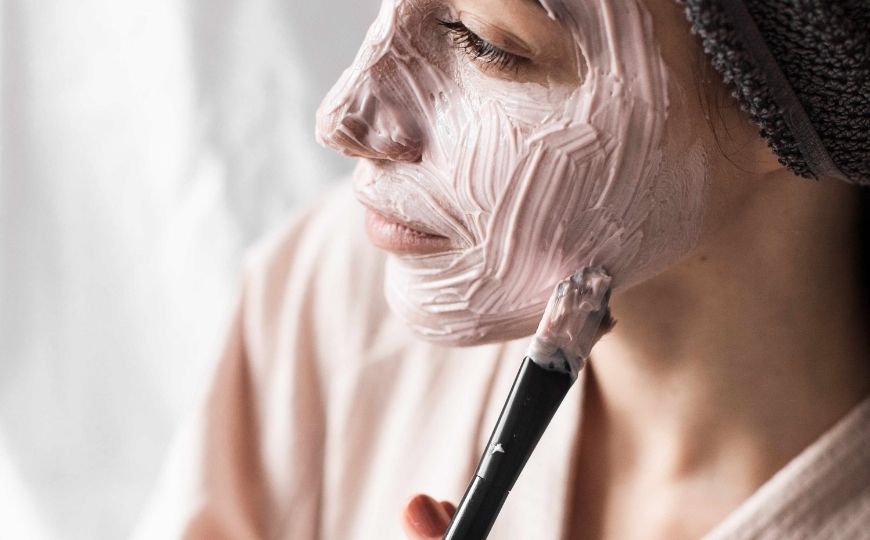 A woman applying a beauty mask on her face